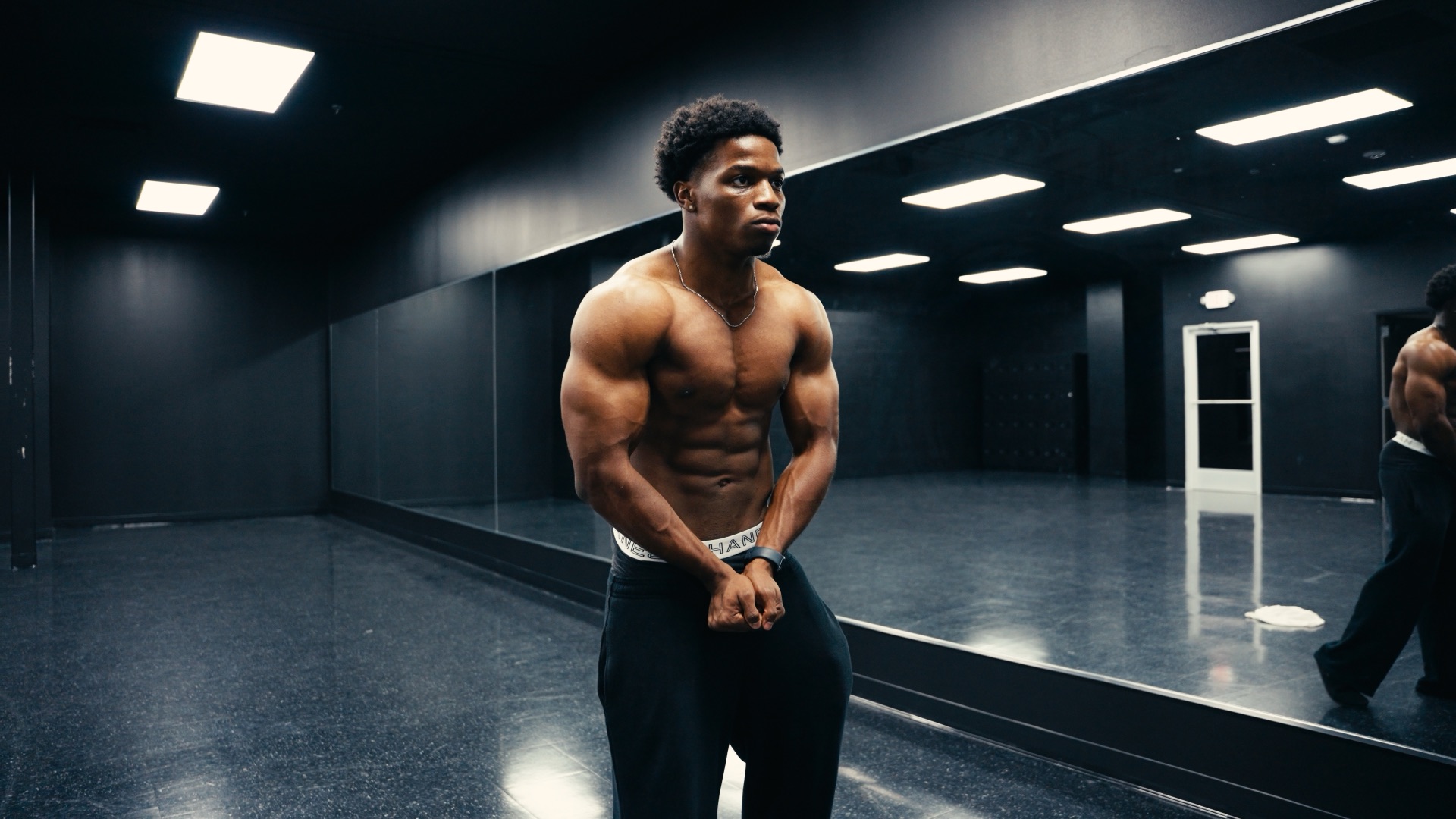 Front-facing physique in a dark mirrored studio